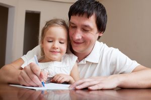 father helping young daughter to be a writer