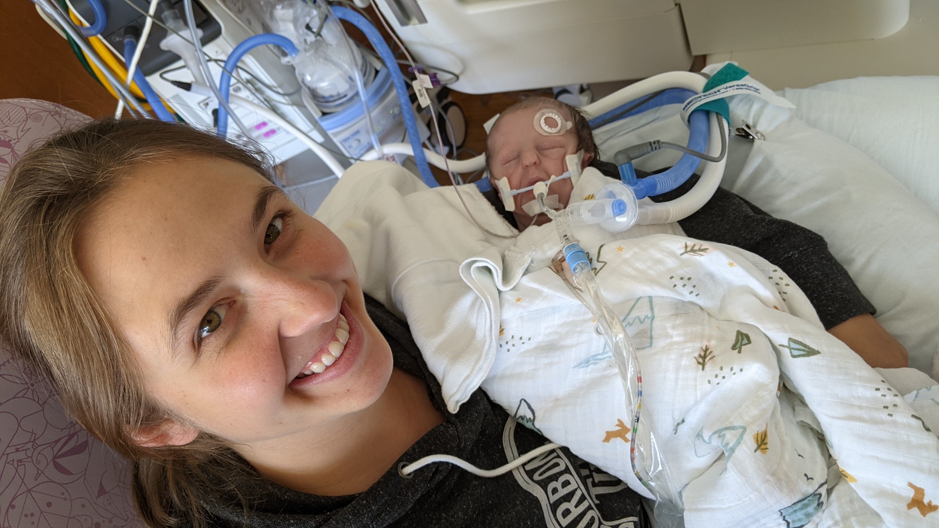 Becky cuddling our son Wyatt in the NICU while he is on ventilator