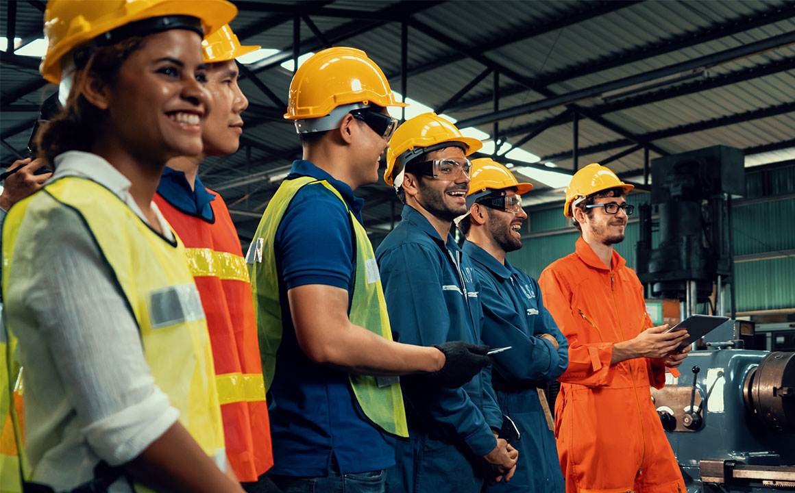 The FlexTrades team of technicians standing in unison at a factory.
