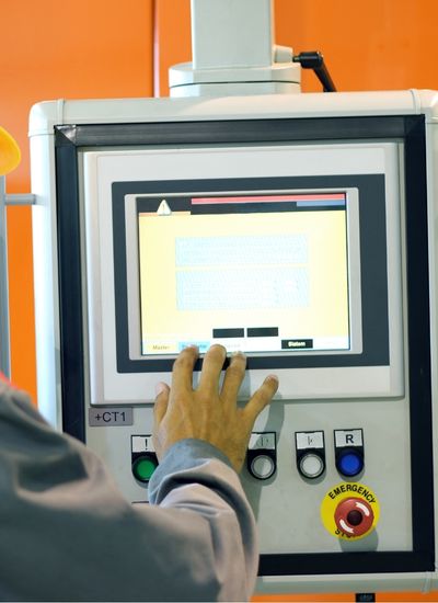 Hands working at the controls of a machine