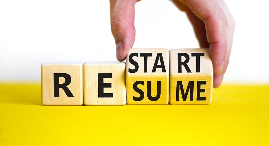 Restart and resume symbol. Businessman hand turns cubes and changes the word 'recovery' to 'resume'. Beautiful white background. Business, restart and resume concept. Copy space.